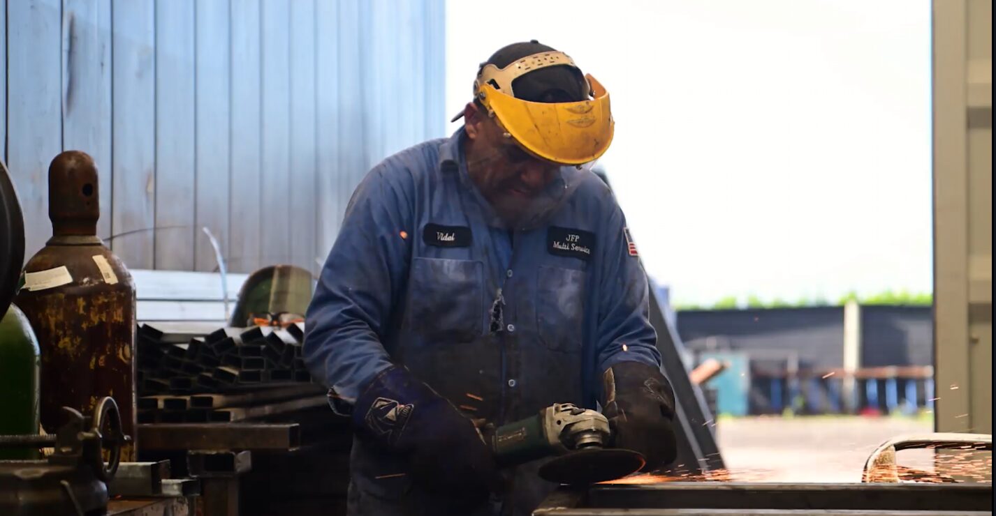 Skilled welder fabricating steel components for modular classrooms
